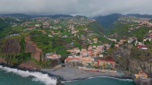 Vue par Drone : ville côtière nichée sur les pentes des montagnes sous un ciel nuageux et l'eau de l'océan