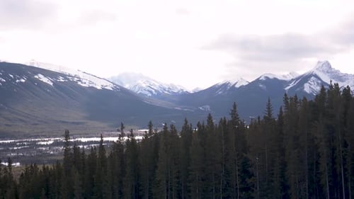 Scenic pan across snow capped trees and mountains in the canadian rockies Canada