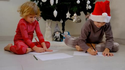 Children Writing Christmas Letters by Christmas Tree