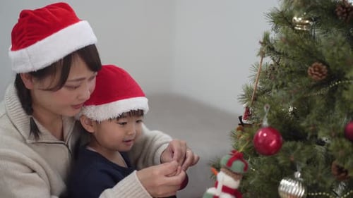 Mother and Child Decorate Christmas Tree Together