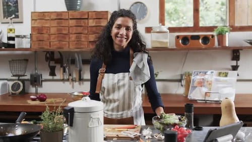 Smiling Woman in Apron Standing in a Rustic Kitchen