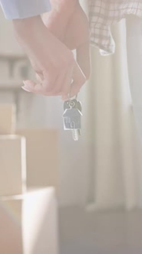 Closeup Slow Motion of a Couple Holding Keychain with Keys of New Apartment in Their Hands