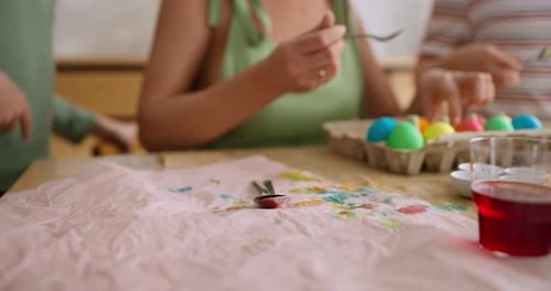 Close Up Spoons Lie on a Cloth with Multicolored Dyes While Painting Eggs for Easter in a Family at