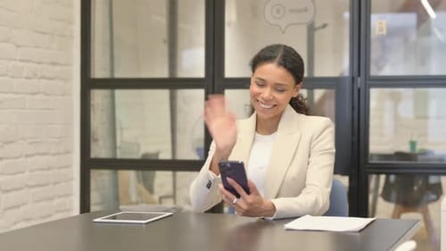 African Woman Doing Video Chat on Phone in Office