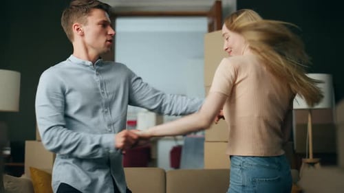 Young Couple Dancing in New Home After Moving