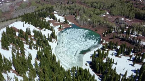 Extreme wide aerial drone shot of Desolation Lake in Utah’s Big Cottonwood Canyon. The camera rotate