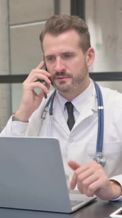 Middle Aged Doctor Talking on Phone in Clinic, vertical video