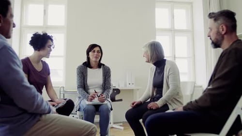 Support Group Sitting in Circle Talking in Bright Room