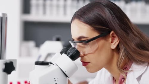 Woman Scientist Using Microscope in Modern Laboratory