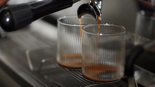 Espresso machine pouring coffee into two glasses