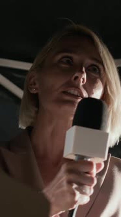 Woman Reporting Into Microphone at a Broadcast