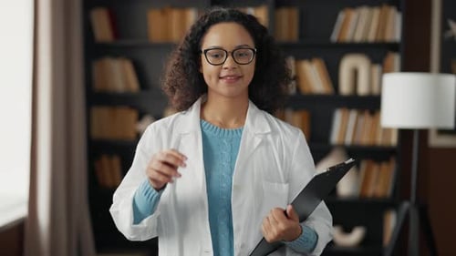 Joven doctora en el consultorio del hospital, estudiante de medicina seria, con bata médica blanca en