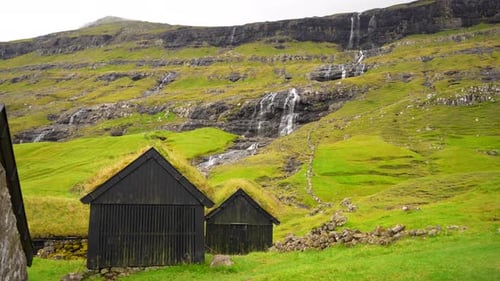 Estabelecendo uma foto panorâmica da vila de Saksun com relva, casas, telhados, Faroe