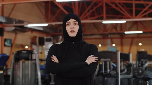 Young Muslim Female Athlete in a Hijab Crossing Her Arms on Her Chest and Looking at the Camera with