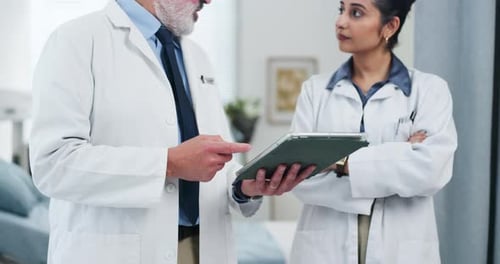 Doctors Discussing Patient Data on a Tablet Device