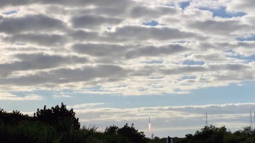 A view of a rocket taking off and flying into space through the clouds.