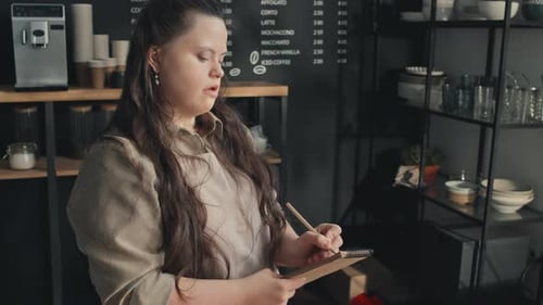Cafe Worker With Disability Making Notes