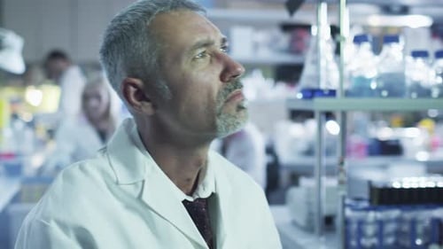 Senior Scientist Contemplates Research in Modern Laboratory