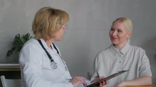 Doctor Consults with Young Woman Patient in Office