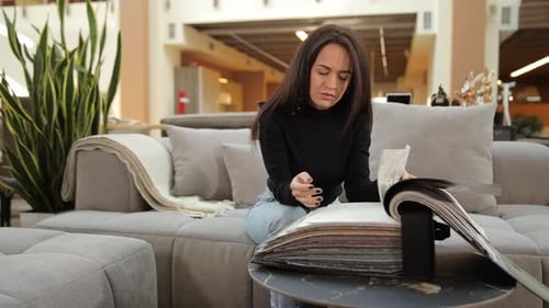 Woman Examining Samples in a Furniture Showroom