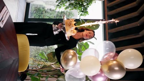 Woman Celebrates Birthday with Cake and Balloons Indoors