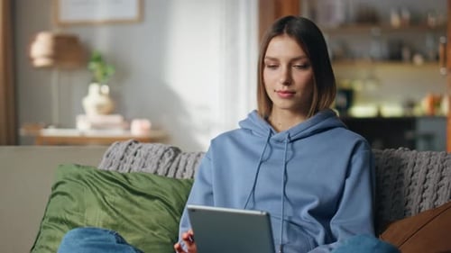 Woman Using Tablet on Couch at Home