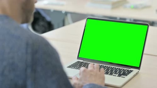 Man Using Laptop with Green Screen