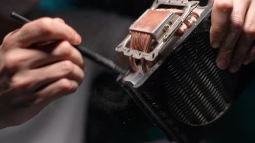 Hands Cleaning Dusty CPU Cooler with a Brush