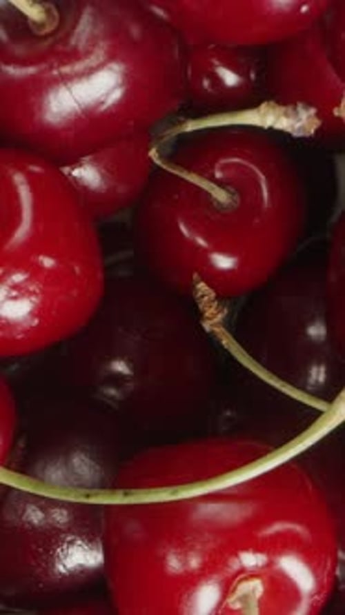 Vertical video. Close-Up Background of Cherries, Rotating and Macro Zoom, Top View.