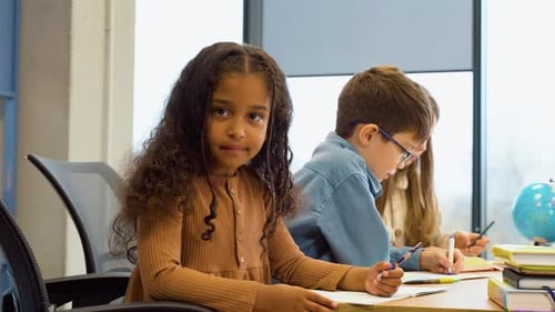 African American Schoolgirl Sitting in Classroom During Lesson in Elementary School