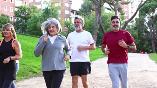 Group of Active Seniors Running Together in a City Park