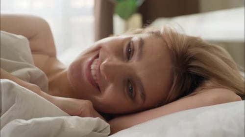 Woman Smiling and Relaxing in Bed