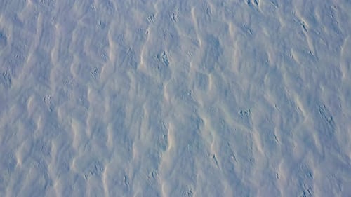 Aerial TOPDOWN flying backwards over the patterns in the fresh snow