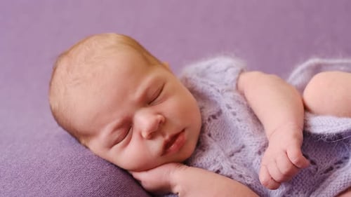 Sleeping Infant Wearing a Knitted Blue Outfit
