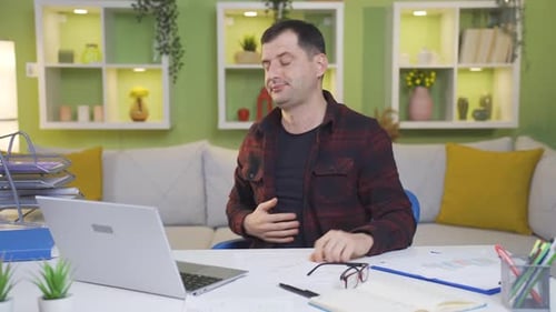 Tired and exhausted man working from home falls asleep at the table.