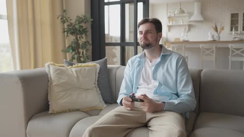 Young Adult Playing Video Games on Couch