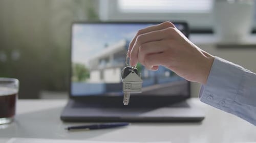 Seller Passing Keys to Client during Real Estate Agreement in Office