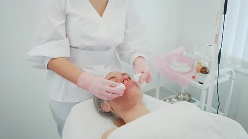 Woman Performing Medical Health Care Procedure Focusing on Facial Cleansing Female Gently Using