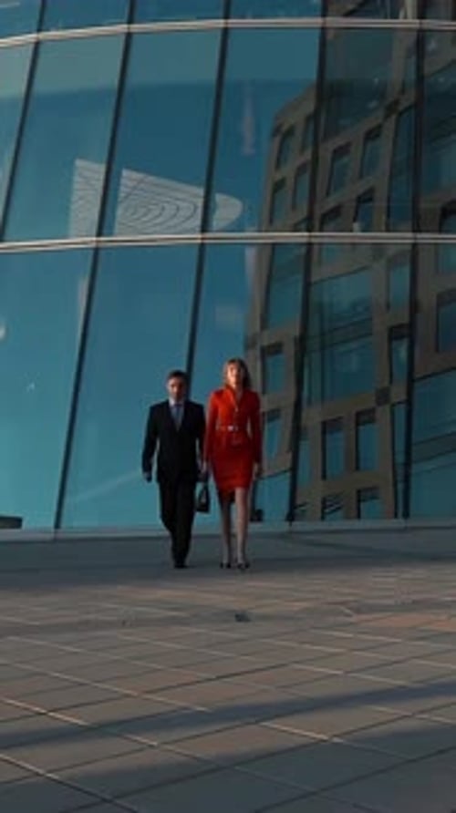 Vertical of Couple of Business People Walking Near Business Centre