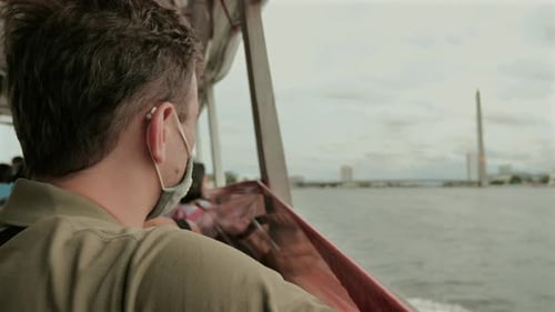 Man Wearing Mask While Commuting on Boat