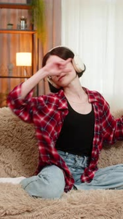 Woman Listening to Music and Dancing on Sofa