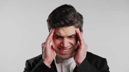 Stressed Man Massaging Temples in Studio