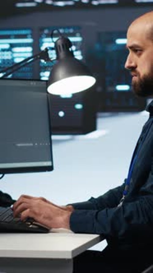 Vertical Video IT Specialist in Server Farm Ensuring Valuable Data Remains Shielded