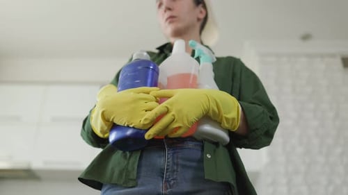 Tired Woman Worker with Cleaning Products Pausing in Kitchen