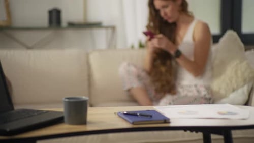 Woman Relaxes on Sofa with Mobile Phone