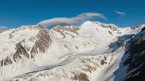Drone Timelapse of clouds flowing over a mountain range in winter.
