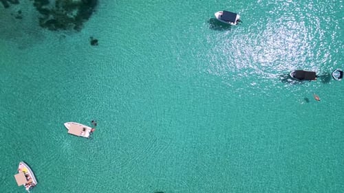 Aerial View of Boats Anchored in Shallow Turquoise Water Near the Coast Clear Sea Swimmers and