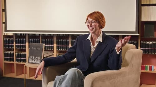 Woman Talking and Gesturing While Sitting in Library