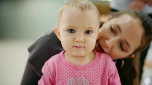 Loving Mother Holding and Kissing Adorable Baby