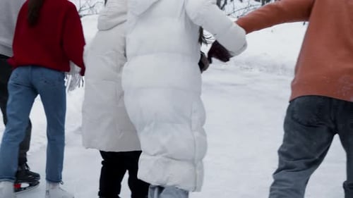 Group of Friends Skating on Snowy Winter Day